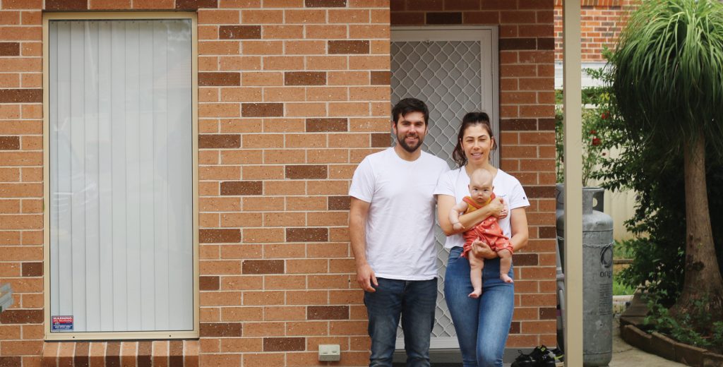 Young family that participated in the Fairfield Secondary Dwelling study, standing at the front of their granny flat.